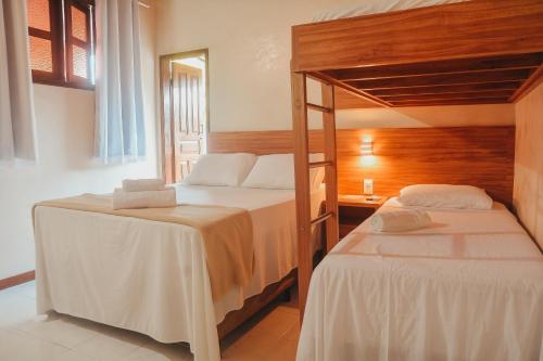 a bedroom with two bunk beds and a mirror at Pousada da praça in Morro de São Paulo