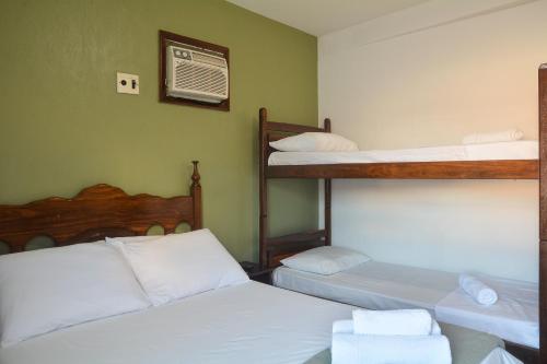 a bedroom with two bunk beds and a fan at Pousada da praça in Morro de São Paulo
