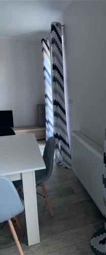 a room with a white table and a chair at Apartamenty Bezrzecze in Szczecin