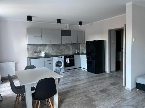 a kitchen with a table and chairs in a room at Apartamenty Bezrzecze in Szczecin