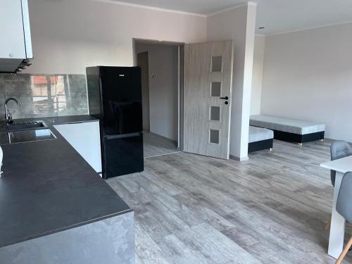 a kitchen with a black refrigerator in a room at Apartamenty Bezrzecze in Szczecin