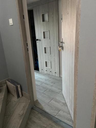 a hallway with a door and a tile floor at Apartamenty Bezrzecze in Szczecin