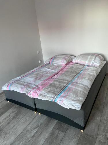 a large bed in a room with a wooden floor at Apartamenty Bezrzecze in Szczecin
