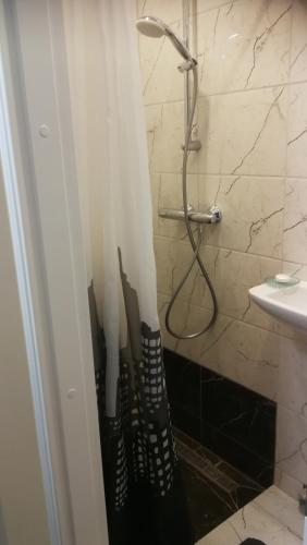 uma casa de banho com chuveiro e guarda-sóis. em Studio nearby the Kalnciema quarter em Riga
