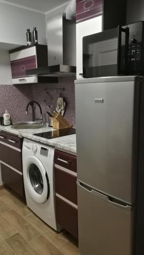 a kitchen with a washing machine and a refrigerator at Studio nearby the Kalnciema quarter in Rīga