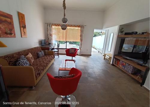 - un salon avec un canapé et une table dans l'établissement Schöne Wohnung in Puerto de la Cruz mit Garten., à Puerto de la Cruz