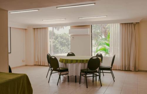 a dining room with a table and chairs and a window at Hotel Faranda Express Puerta Del Sol Barranquilla, A Member of Radisson Individuals in Barranquilla