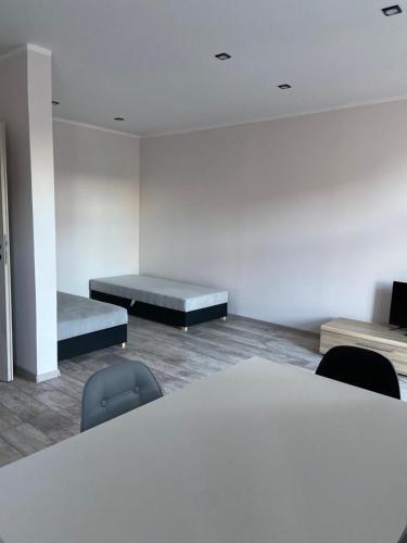 a room with two beds and a table and chairs at Apartamenty Bezrzecze in Szczecin