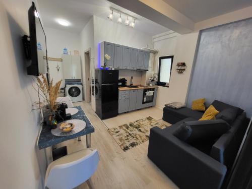 a living room with a black couch and a kitchen at Seb apartment mamaia nord in Năvodari