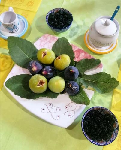 a plate of apples and leaves on a table at Casa Susanna Rural Sardinia in Sini