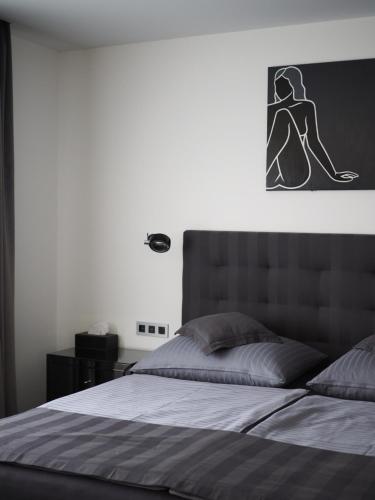 a bedroom with a bed with a picture on the wall at Apartman Grey in Prague