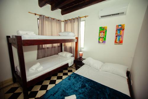 ein Schlafzimmer mit 2 Etagenbetten und einem karierten Boden in der Unterkunft Casa Hotel Marbella Beach in Cartagena de Indias