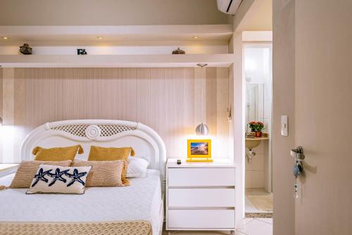 a bedroom with a bed with a white headboard at VARANDA GOURMET c churrasqueira-3 quartos- Wi-fi in Bertioga