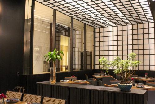 a restaurant with tables and chairs and a large mirror at Mercure Belo Horizonte Lourdes in Belo Horizonte