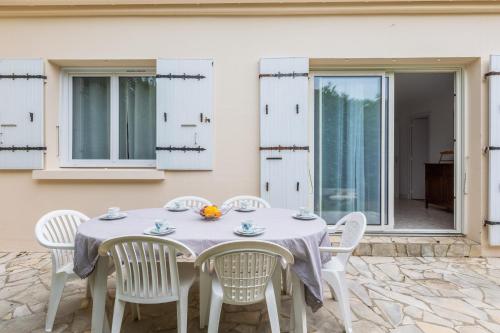 - une table et des chaises blanches sur la terrasse dans l'établissement Maison des Demoiselles - Welkeys, à Puilboreau