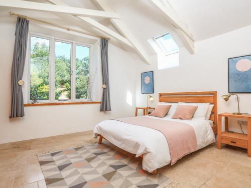 金斯布里奇的住宿－Linham Barn，一间卧室设有一张大床和一个窗户。