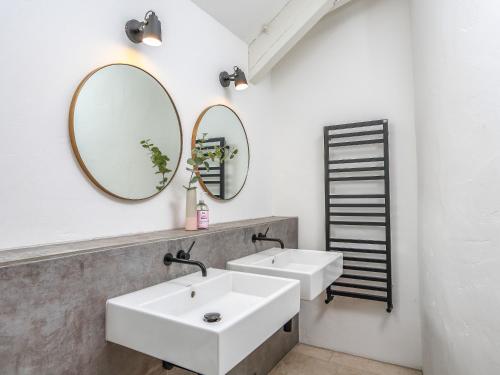 a bathroom with two sinks and a mirror at Linham Barn in Kingsbridge