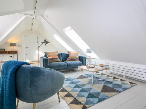 a living room with a blue couch and a table at Linham Barn in Kingsbridge