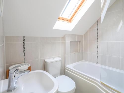 a bathroom with a toilet and a sink and a bath tub at Linham Barn in Kingsbridge