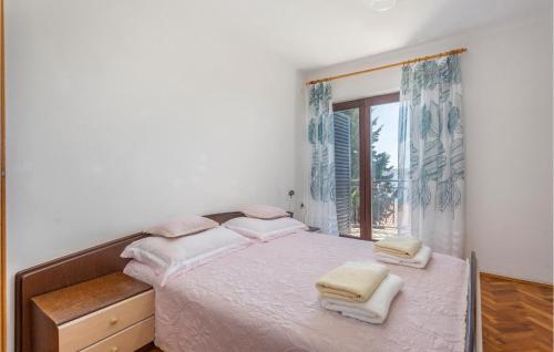 een witte slaapkamer met een bed met handdoeken erop bij Lovely Apartment In Omisalj With House Sea View in Omišalj