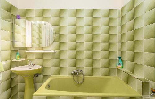 een badkamer met een groen bad en een wastafel bij Lovely Apartment In Omisalj With House Sea View in Omišalj