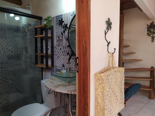 a bathroom with a toilet and a glass shower at Casa da Mi Temporada - Tiny House in Lençóis