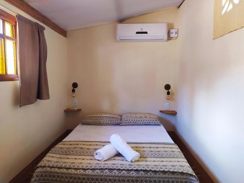 Un pequeño dormitorio con una cama con toallas. en Casa da Mi Temporada - Tiny House en Lençóis