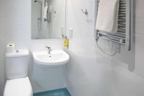 a white bathroom with a toilet and a sink at Best Western Lancaster Morecambe Lothersdale Hotel in Morecambe