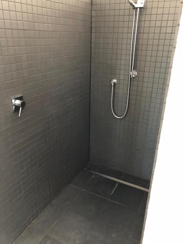 a shower in a bathroom with gray tiles at Mt Barker in Wanaka