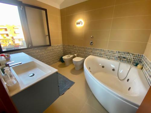 a bathroom with a tub and a sink and a toilet at Penthouse Le Isole - Luxury rooftop retreat in Marsala