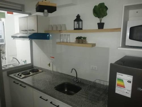 a small kitchen with a sink and a refrigerator at Amplio Depto en Viña del Mar con Estacionamiento. in Viña del Mar
