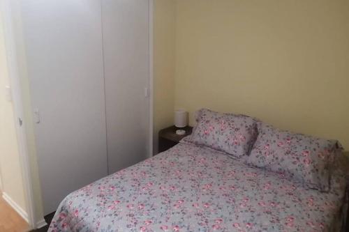 a bedroom with a bed with a flowered comforter and a table at Amplio Depto en Viña del Mar con Estacionamiento. in Viña del Mar