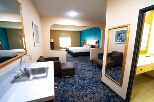 une chambre d'hôtel avec un lavabo et une chambre dans l'établissement Quality Inn & Suites, à Monroeville