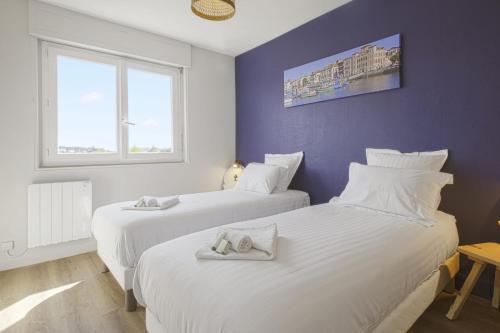 deux lits dans une chambre avec deux fenêtres dans l'établissement Appartement Tiera - Welkeys, à Biarritz