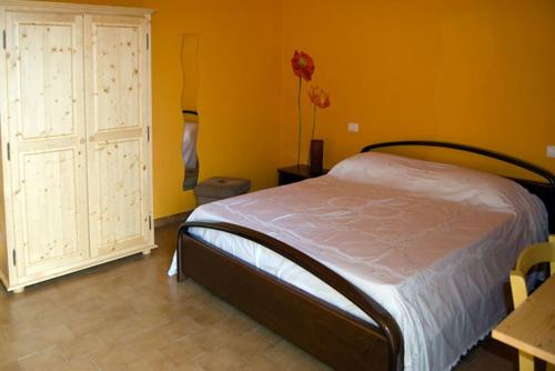 - une chambre avec un lit et un mur jaune dans l'établissement B&B La Gatta, à Vignale