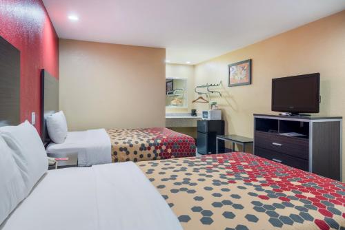 a hotel room with two beds and a flat screen tv at Econo Lodge Lake Charles University Area in Lake Charles