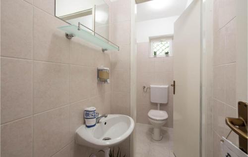 Baño blanco con lavabo y aseo en Lovely Home In Dugopolje With Wifi, en Split