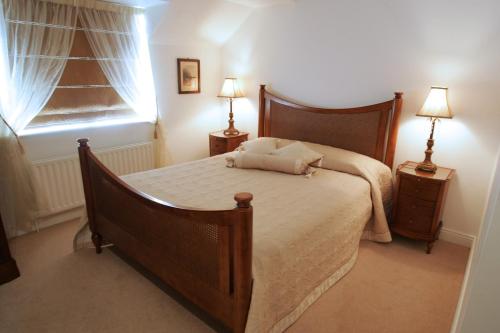 a bedroom with a bed with two night stands and two lamps at Heatons Guesthouse in Dingle