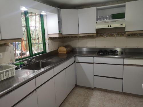 a kitchen with white cabinets and a sink at Preciosa Finca en el Eje Cafetero, Quindío- Colombia in Montenegro