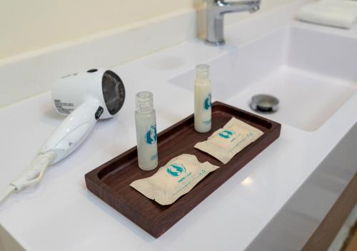 a wooden tray with three bottles on a bathroom sink at Aqualina Inn in San Andrés