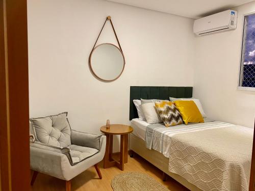 um quarto com uma cama, uma cadeira e um espelho em VILA INDUSTRIAL/C/AR CONDICIONADO em Marília