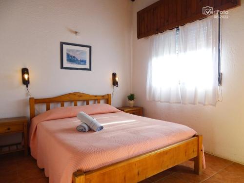 1 dormitorio con cama y ventana en Complejo Dunas del Diablo, en Punta del Diablo
