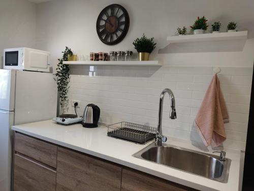 um balcão de cozinha com um lavatório e um frigorífico em רוגע במדבר מרחב עם em Merhav Am