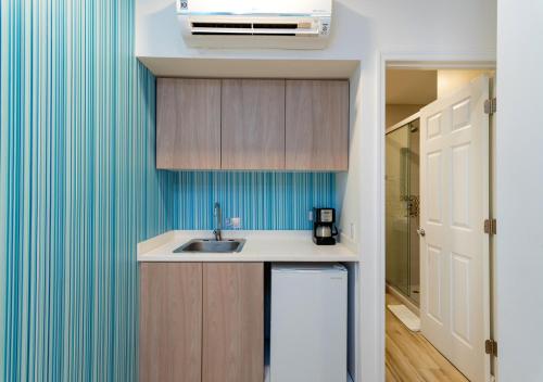a kitchen with a sink and a blue wall at Aqualina Inn in San Andrés