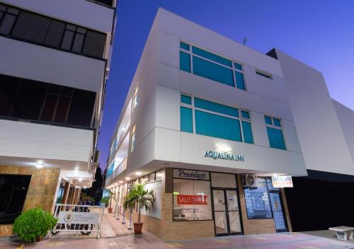a white building with a sign in front of it at Aqualina Inn in San Andrés