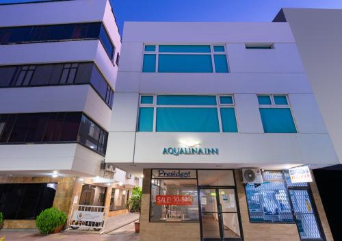 a tall white building with a sign that reads aquinnium at Aqualina Inn in San Andrés