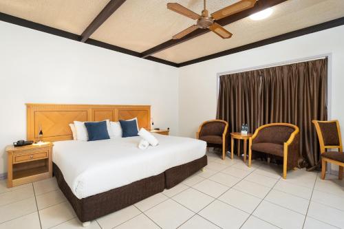 a bedroom with a large bed and a table and chairs at Apollo Motel Biloela in Biloela