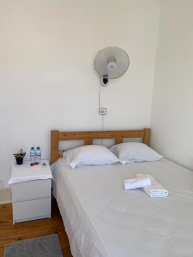a bedroom with a white bed with a fan at Alfama Guest House in Lisbon