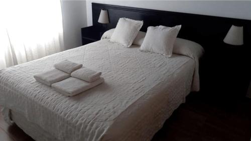 a bedroom with a white bed with two towels on it at El Descanso in Colón