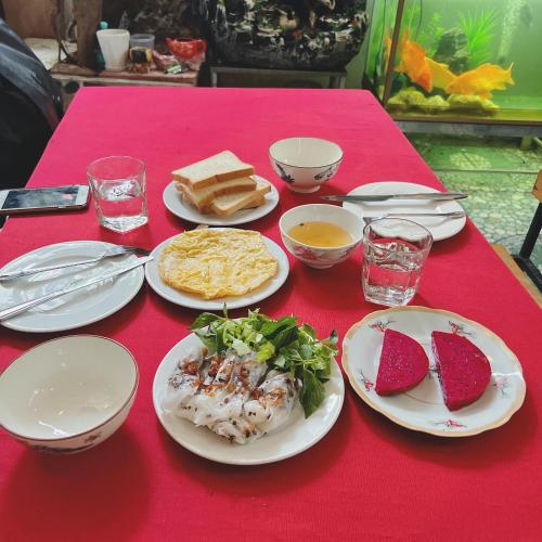 a red table with plates of food on it at Cat Ba Mystery Homestay in Cat Ba